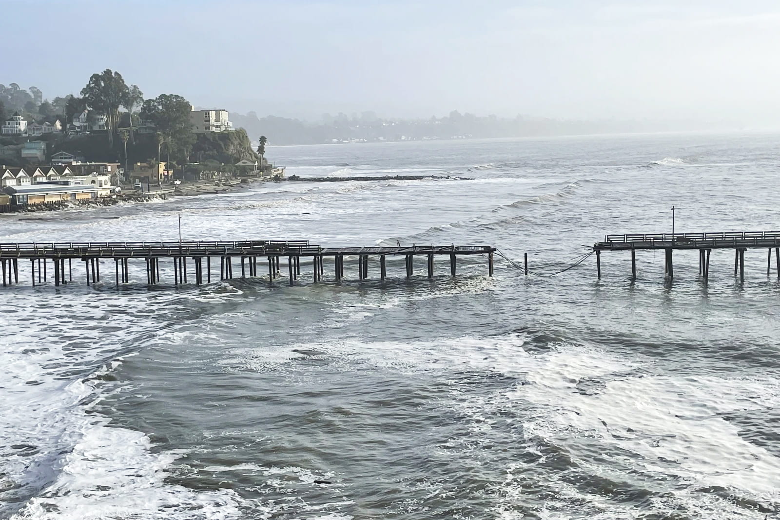Capitola wharf with rough seas and a major section in the middle missing.